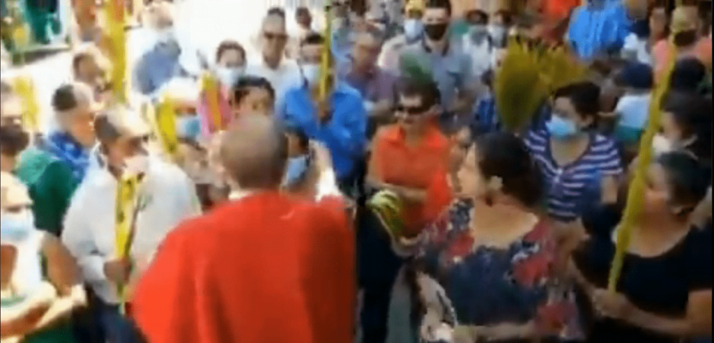 Sacerdota quita cubrebocas a mujer