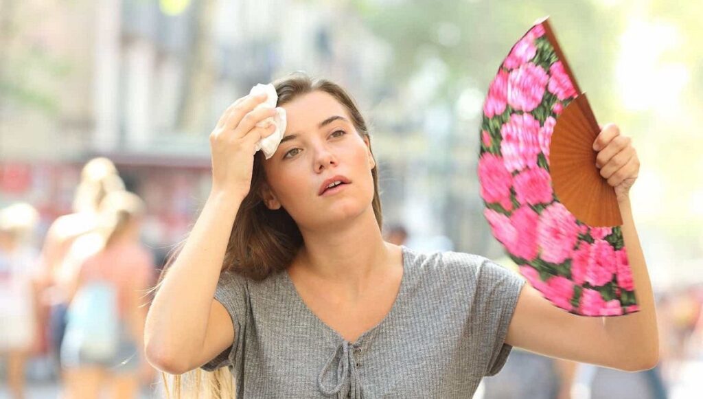 calor mujer cansada fatiga abanico verano