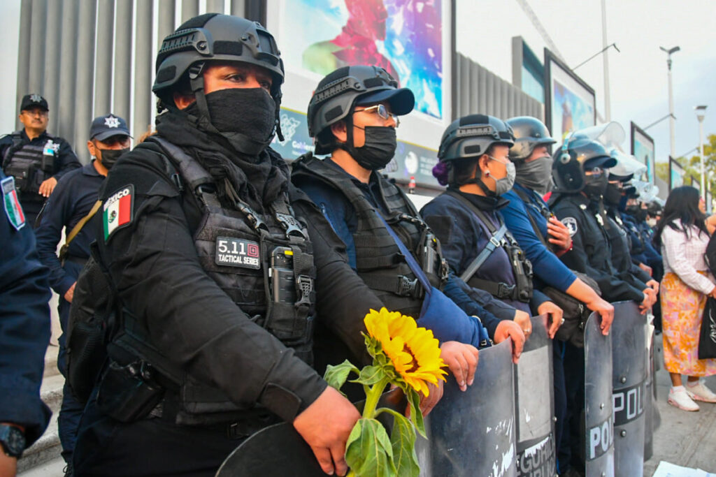 Feministas regalan girasoles a policías