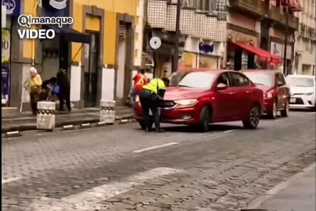 policia de transito poblana intentando quitar una placa