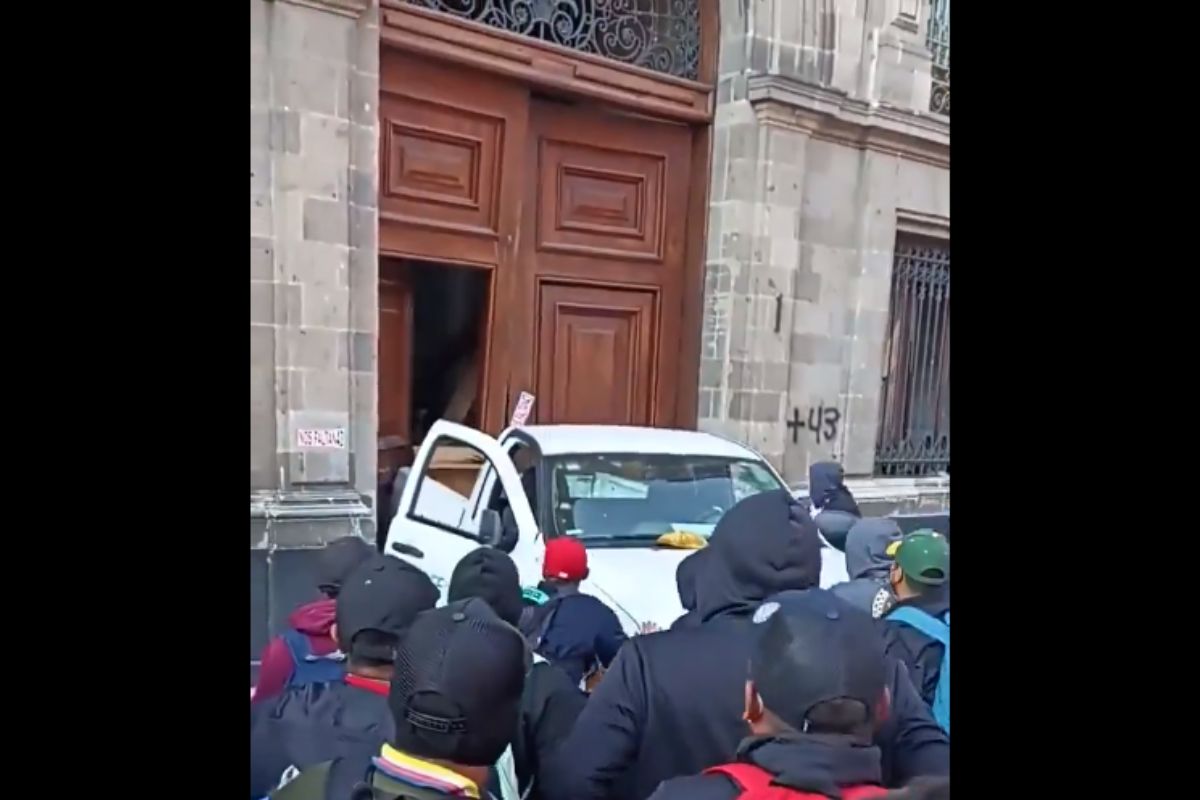 (VIDEO) Normalistas de Ayotzinapa tiran puerta de Palacio Nacional en plena mañanera de AMLO 1 normalistas de Ayotzinapa tiran puerta de Palacio Nacional