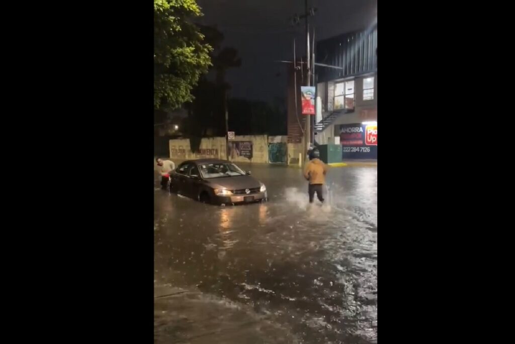 lluvia deja un auto varado en camino real