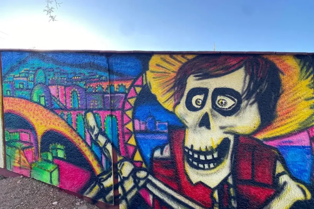 Artista poblano pinta mural de "Coco" en el cementerio de Ahuehuetitla