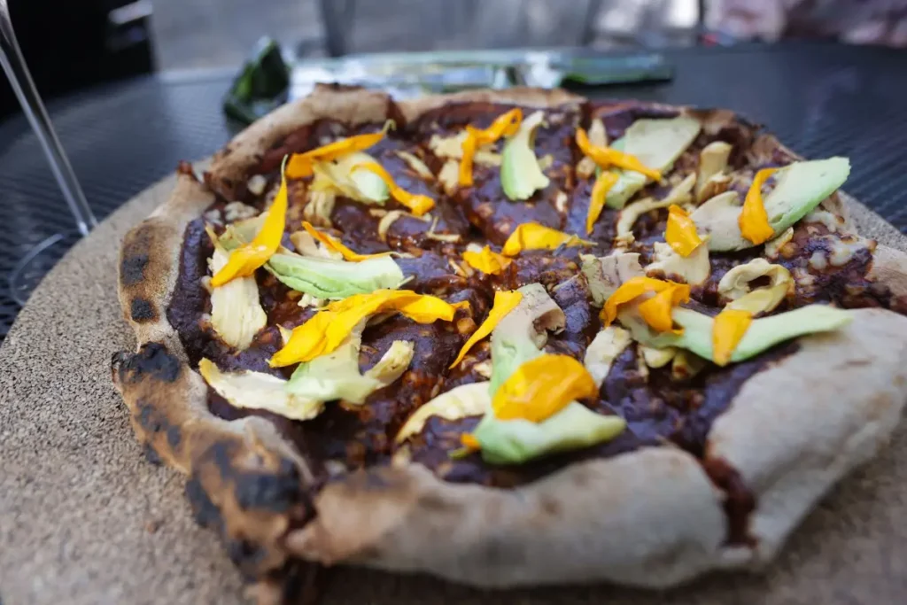 Crean pizza de mole poblano con cempasúchil y cerveza de pan de muerto